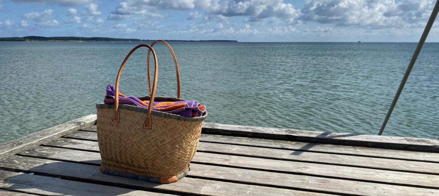 Strandtaske på Sydstrandens badebro i Kerteminde med havet og himlen i baggrunden. 